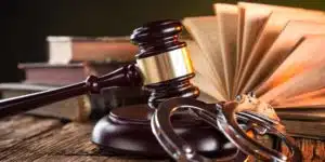 Image of handcuffs, gavel, and law books on a desk